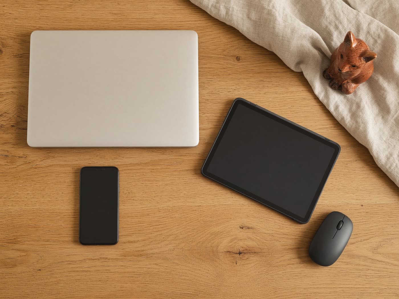 Laptop, Tablet und Smartphone auf einem Holztisch